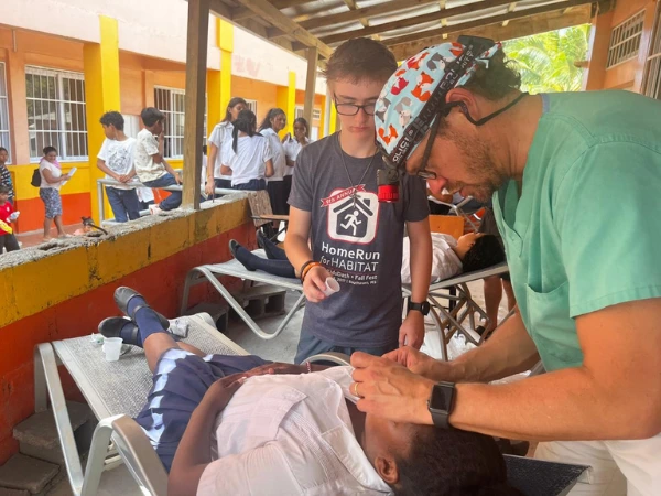 Dr Mac with patient Dr Mac helping patients